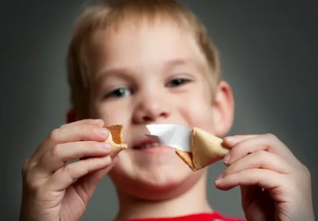 osoba pisząca wr&oacute;żby na małych karteczkach