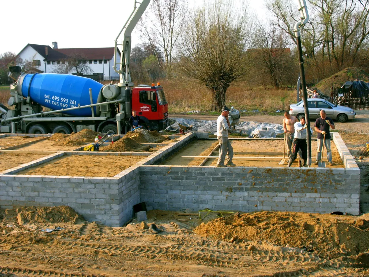 Budowa fundament&oacute;w: betonow&oacute;z i ekipa przygotowują teren, by wiedzieć, czym zasypać fundamenty wewnątrz.