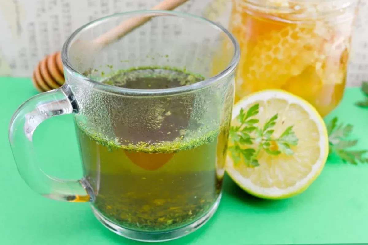 Świeża natka pietruszki, cytryna i woda w szklance