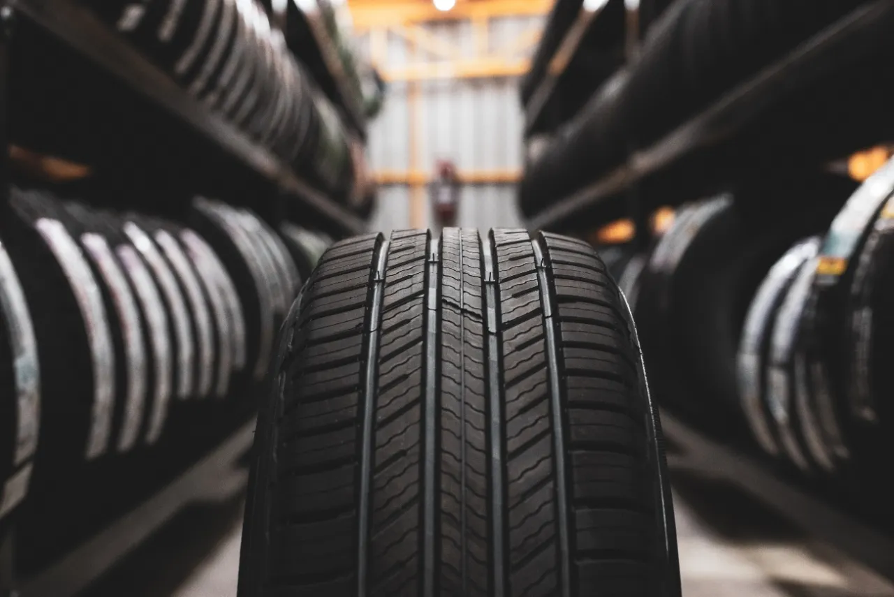 Szukasz idealne opony do BMW X3 xDrive? Na zdjęciu widać bieżnik opony, a w tle regały pełne opon.