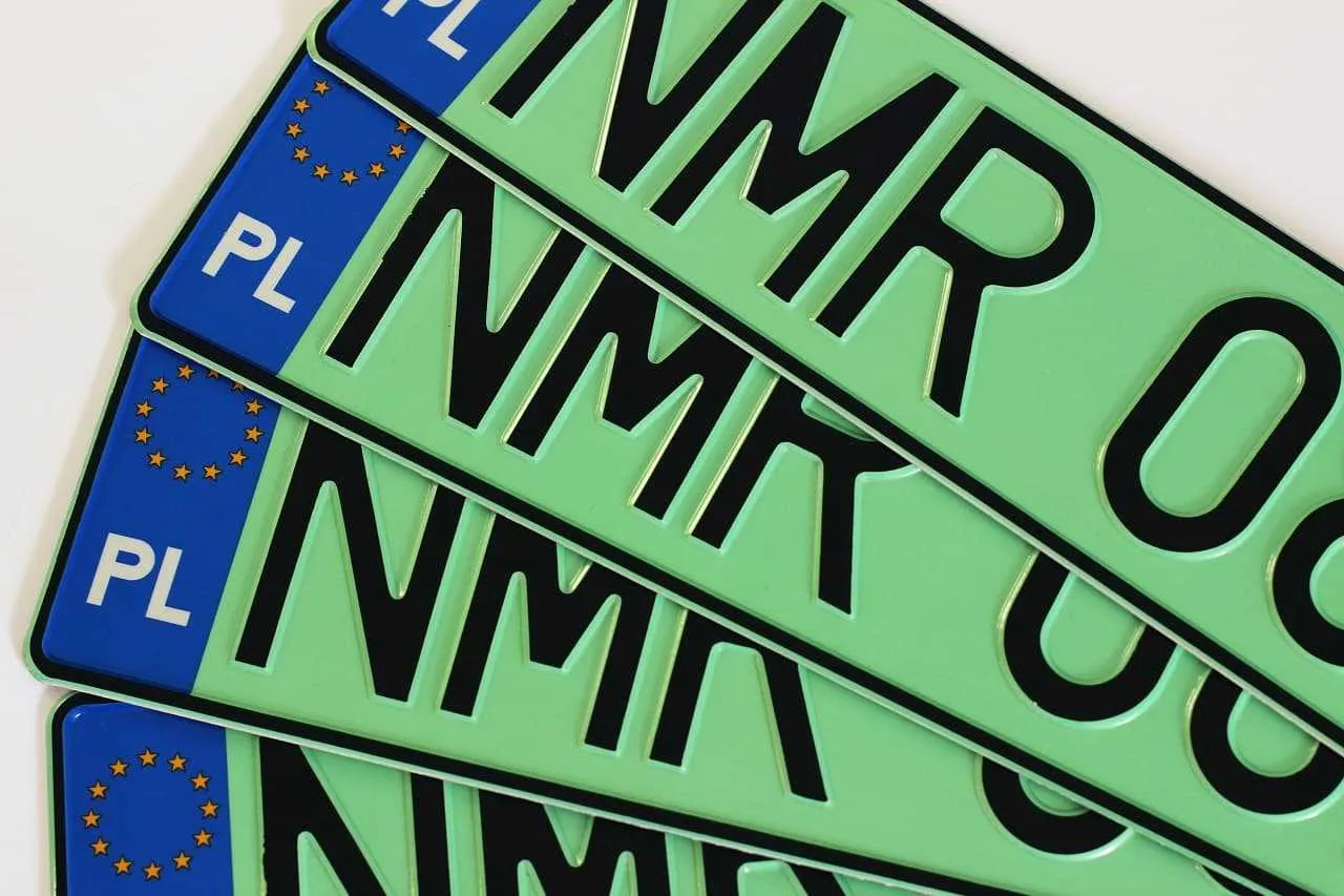 Kilka zielonych tablic rejestracyjnych z literami 