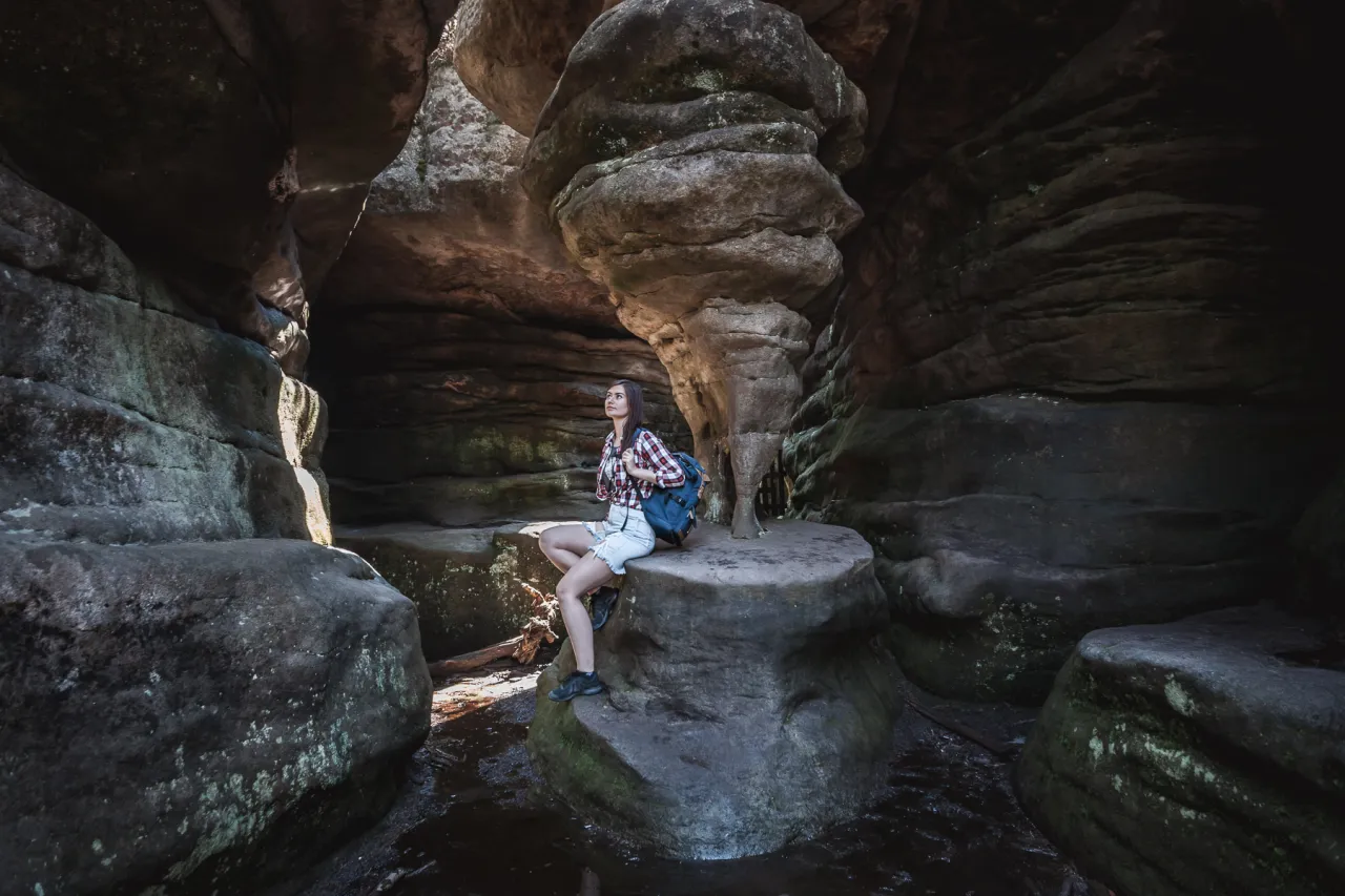 G&oacute;ry Stołowe: turystka podziwia skalne grzyby i labirynty. Co zobaczyć w tym niezwykłym miejscu?