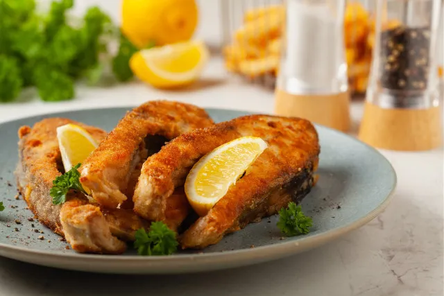 idealnie usmażony karp na talerzu z cytryną