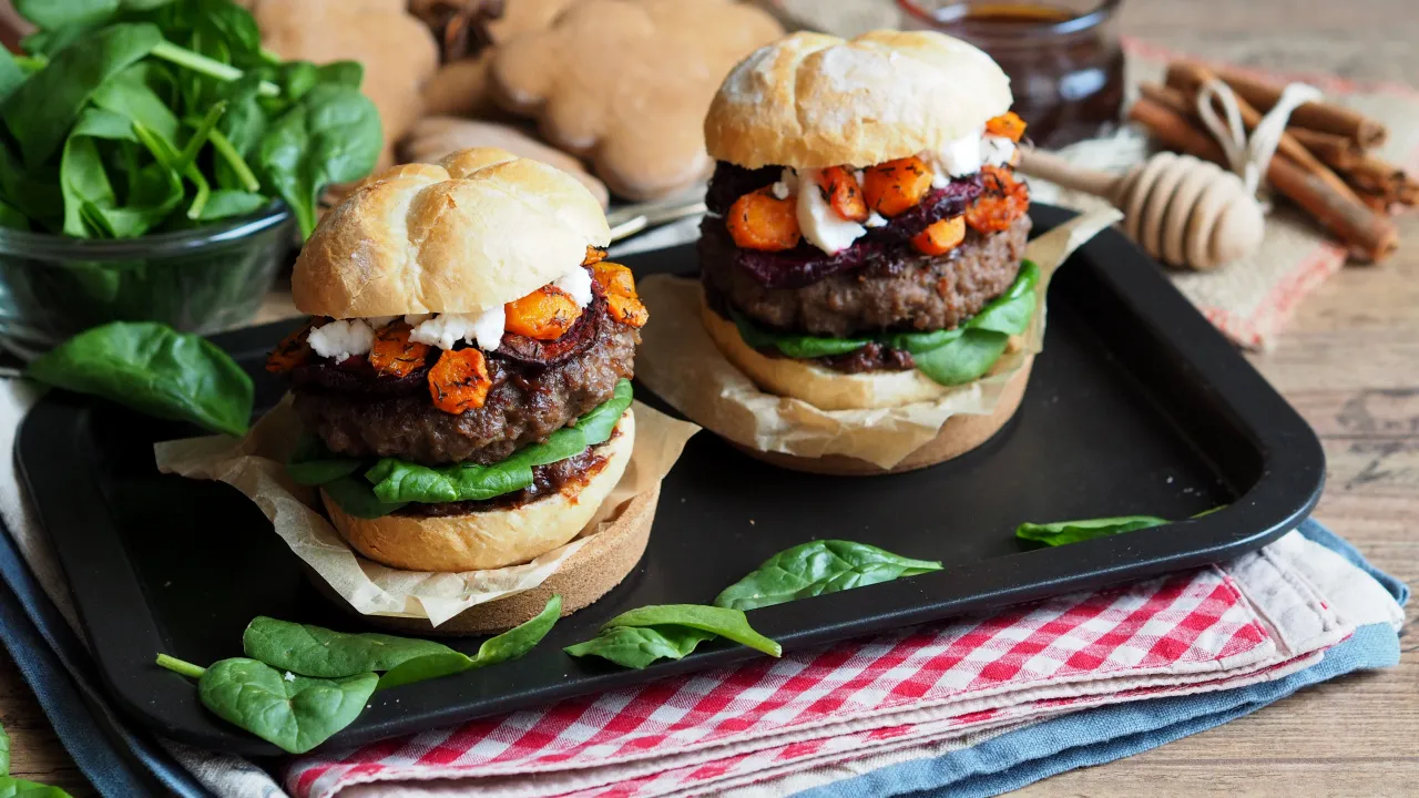 złożony burger z serem, warzywami i sosem