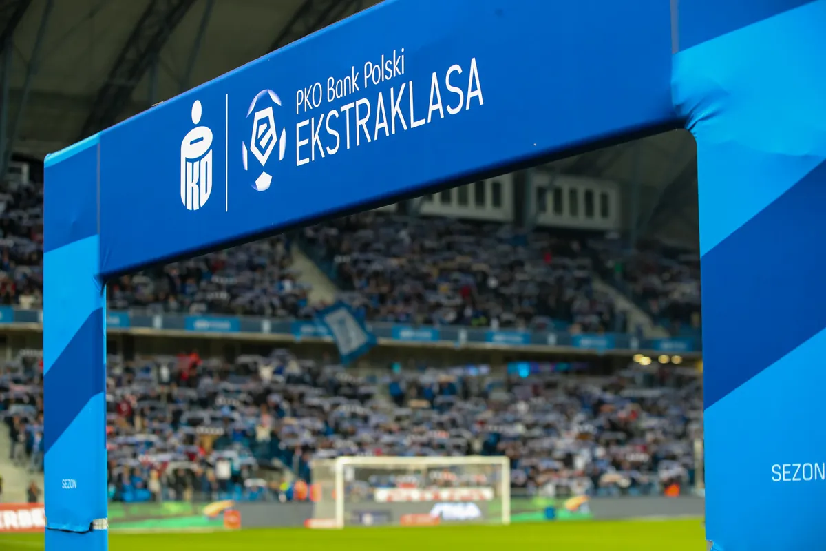 Brama z logo PKO Bank Polski Ekstraklasa na tle trybun pełnych kibic&oacute;w. Czas na emocje, kiedy terminarz ekstraklasy wzywa!