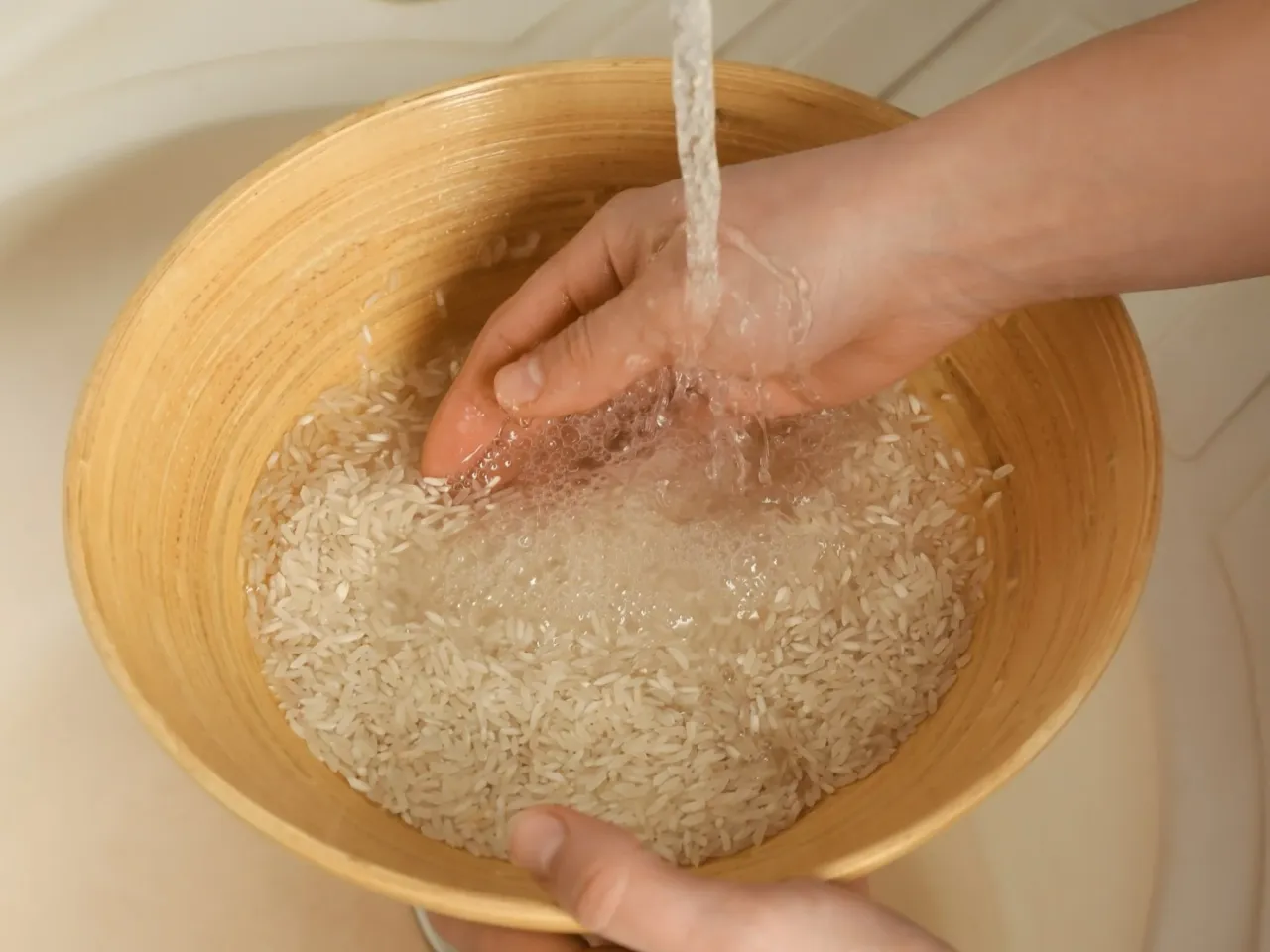 Płukanie ryżu w sitku pod bieżącą wodą