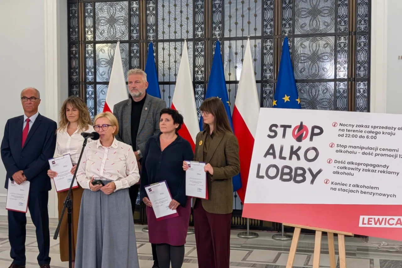 Grupa osób prezentuje transparent 