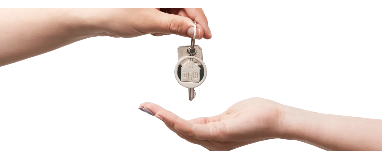 osoba trzymająca klucze do mieszkania i kalkulator