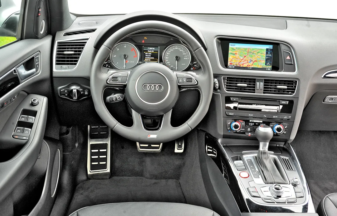 Wnętrze Audi z nawigacją i sportową kierownicą. Zastanawiasz się, które audi wybrać? Ten model oferuje komfort i nowoczesne technologie.