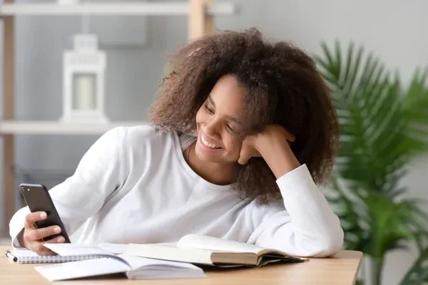 Nastolatek zamyślony nad książkami lub ekranem komputera