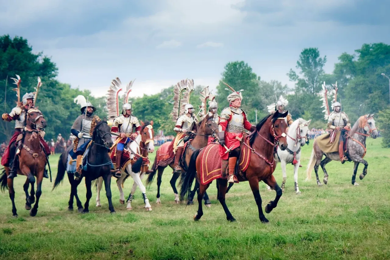 Husaria, żywe polskie mity narodowe, galopuje na koniach w zbrojach i z charakterystycznymi skrzydłami.
