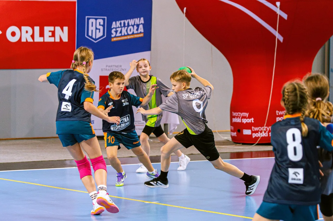 Dzieci trenujące piłkę ręczną w hali sportowej