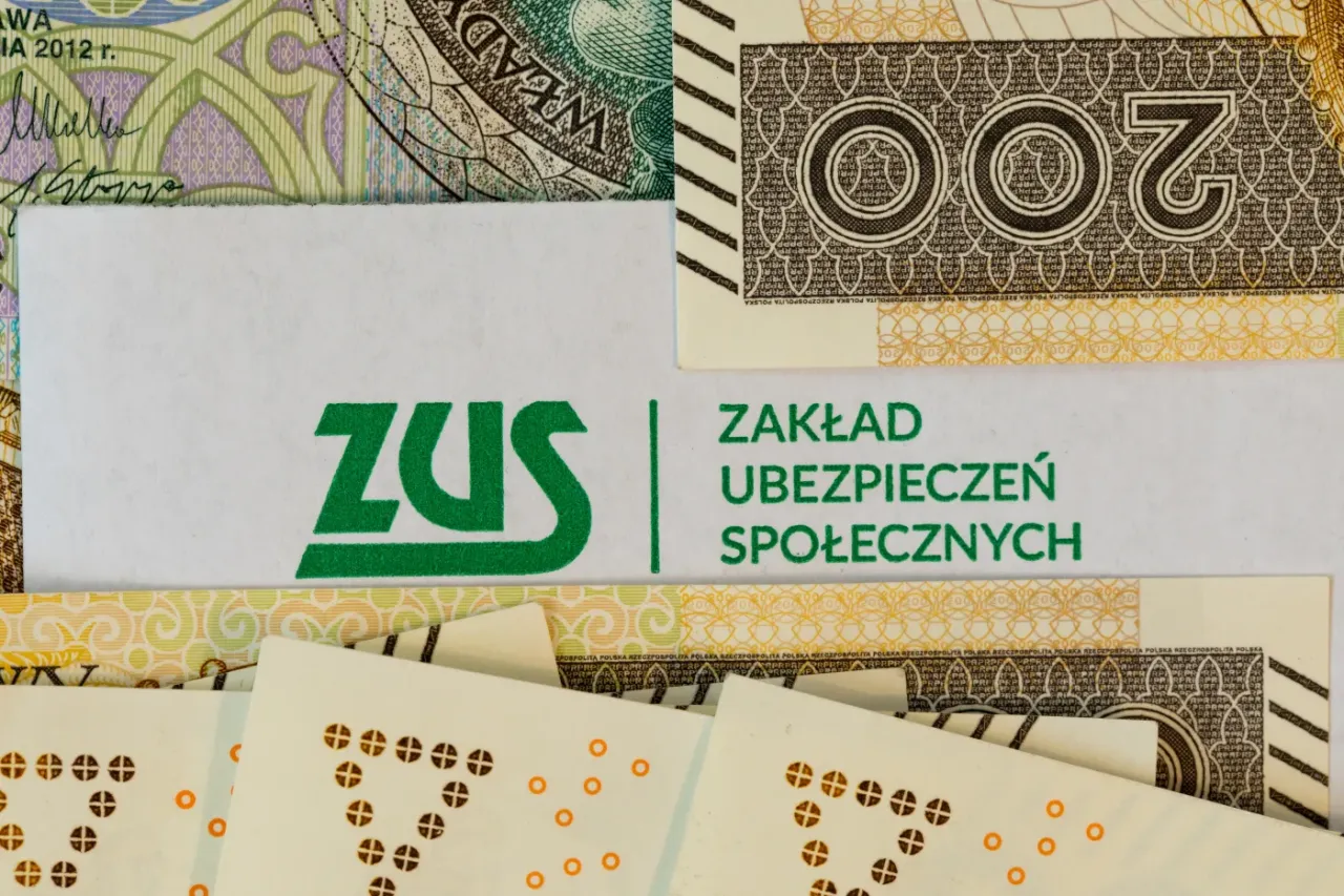 ZUS i banknoty 200 zł. Dokumenty ZUS, l4 na okres wypowiedzenia, symbolizują formalności związane z pracą i ubezpieczeniem.