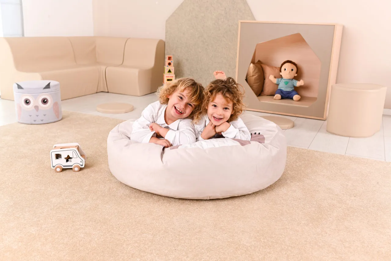 dzieci bawiące się w kręgu na dywanie w klasie