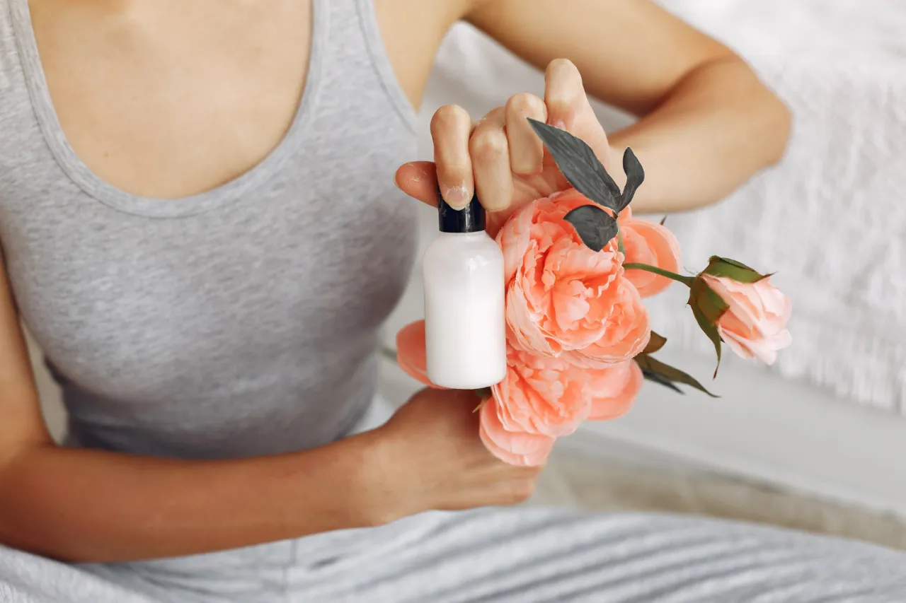 kobieta aplikująca perfumy na nadgarstek