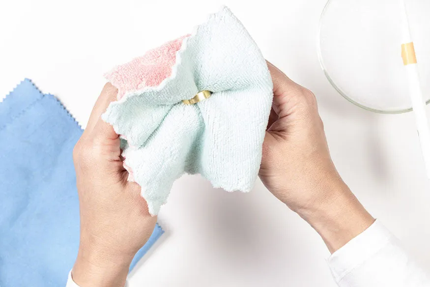 kobieta czyszcząca biżuterię miękką szmatką