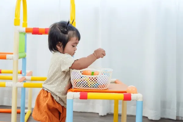 Szczęśliwe niemowlę bawiące się zabawkami sensorycznymi, odkrywające dłonie