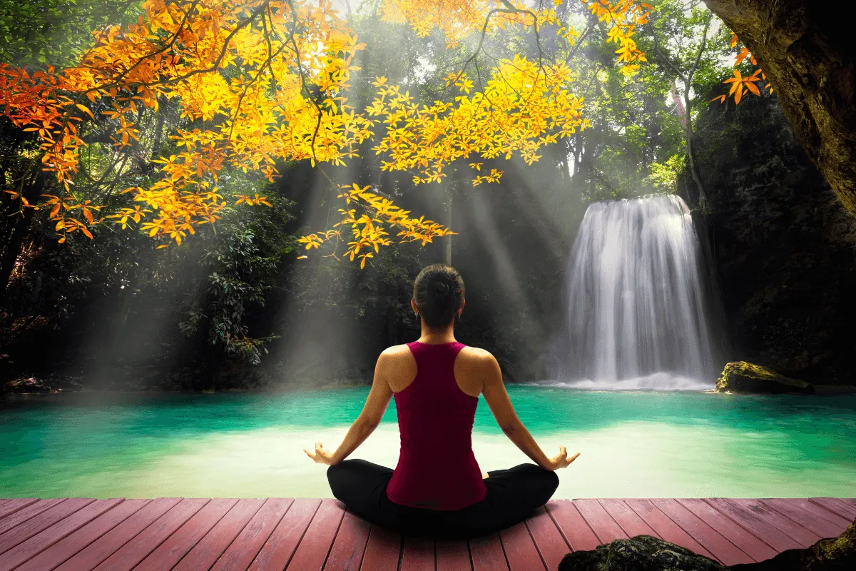 Osoba medytująca, z promieniami światła symbolizującymi korzyści płynące z intencji