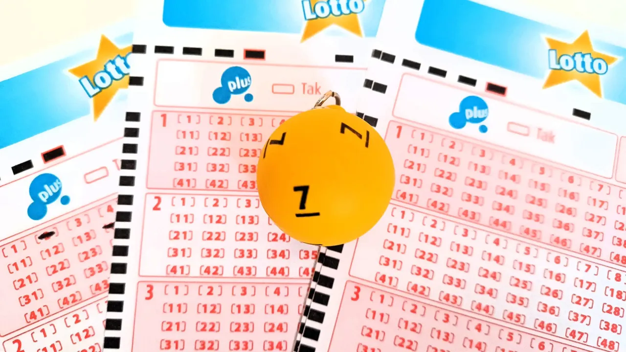 Żółta kulka z numerem 7 na tle kuponów lotto.