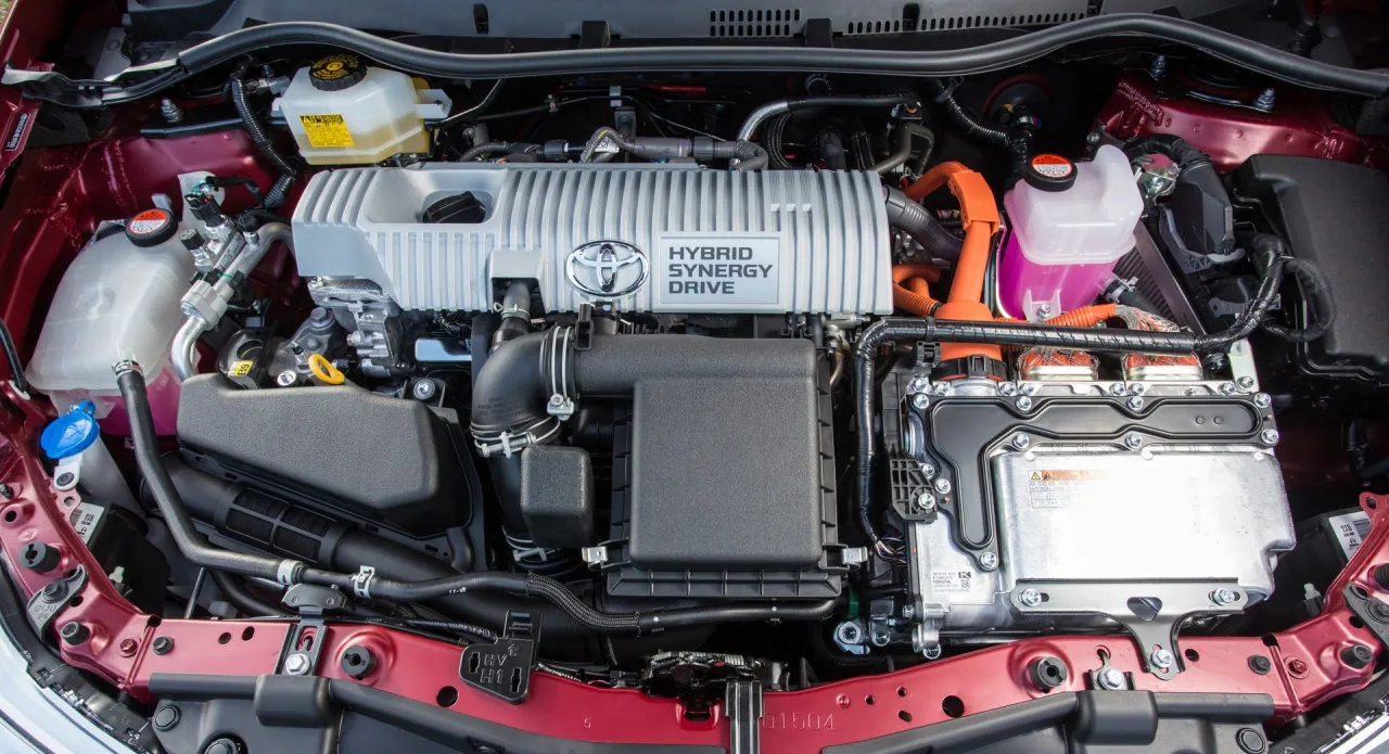 Silnik Toyota RAV4 Hybrid. Akumulator znajduje się w dolnej części zdjęcia, pod srebrną obudową z pomarańczowymi przewodami.