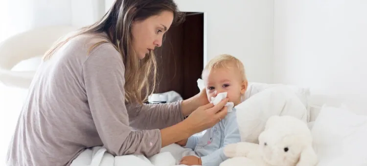 niemowlę z katarem, zatkany nosek, rodzic pomaga dziecku