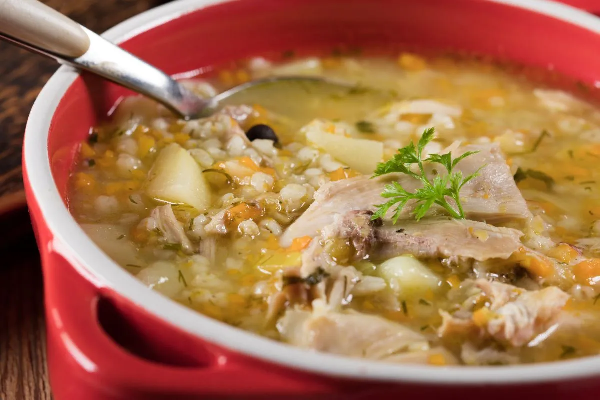 kobieta wąchająca zupę z niepewną miną