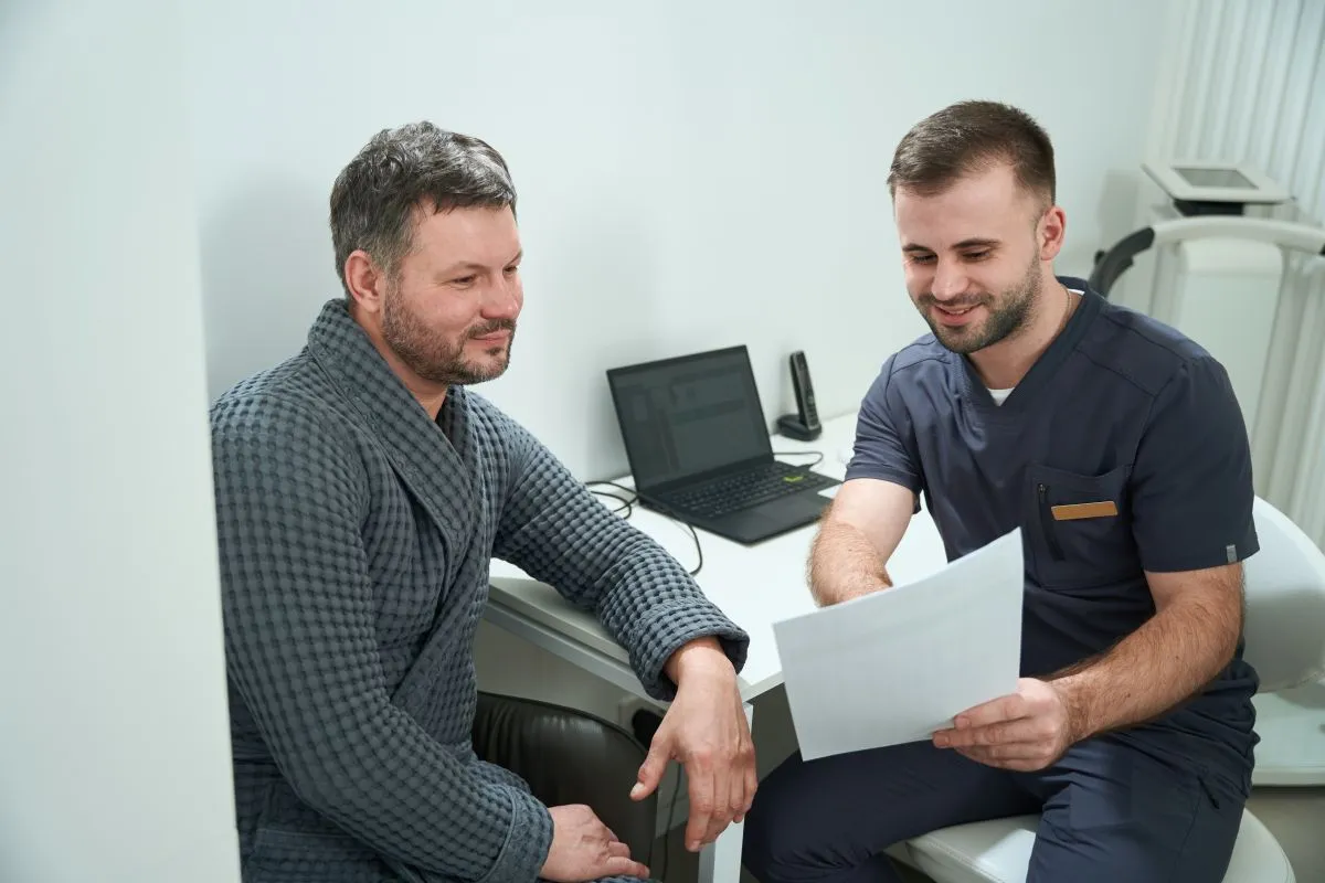 Urolog wyjaśniający pacjentowi przygotowanie do wizyty