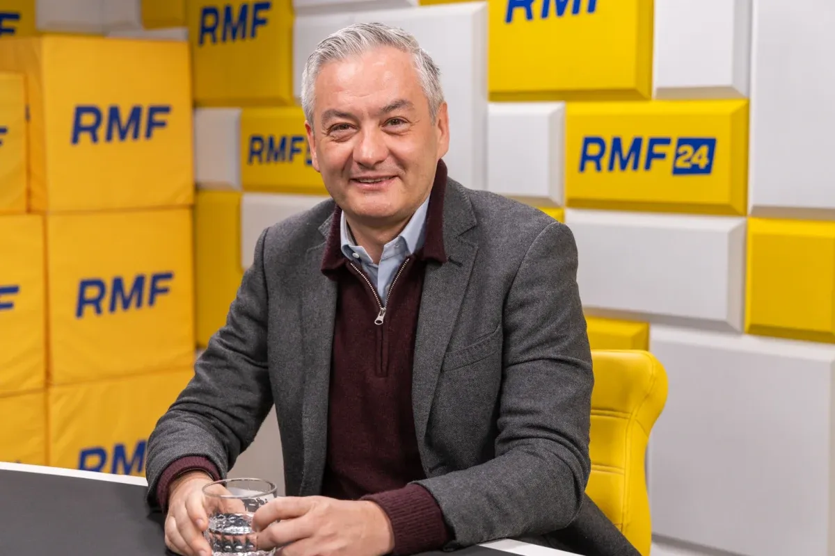Robert Biedroń, zapytany ile lat ma, uśmiecha się do kamery w studiu RMF FM.