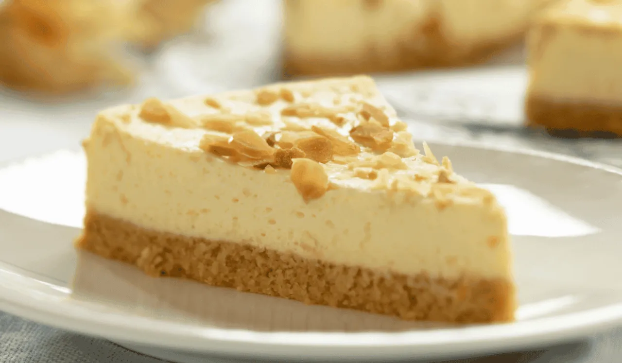 Idealny sernik z chrupiącym spodem i kremowym nadzieniem, posypany płatkami migdałów. Idealny, gdy zastanawiasz się, jak piec sernik w piekarniku.