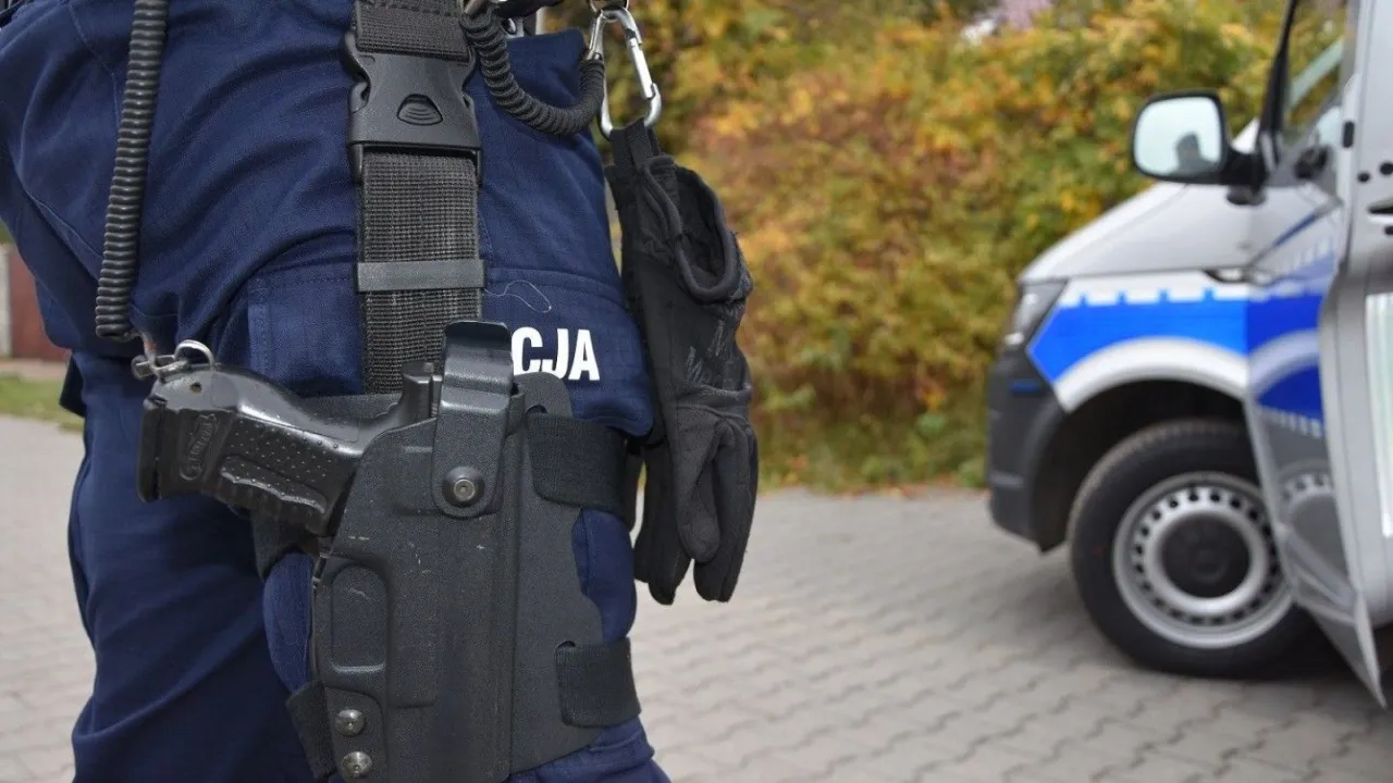 Policjant w mundurze z pistoletem w kaburze przy pasie. Czy myśliwy może nosić broń w miejscu publicznym? To pytanie, na które odpowiedź zależy od przepisów.