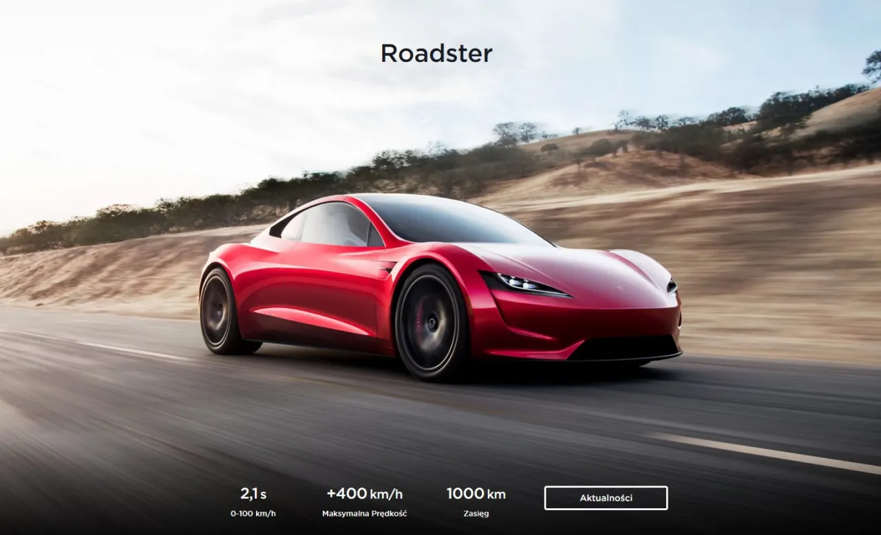 Czerwony Tesla Roadster pędzi po pustej drodze. Dane techniczne: 0-100 km/h w 2,1s, prędkość maks. +400 km/h, zasięg 1000 km. Sprawdź, ile kosztuje Tesla Roadster.
