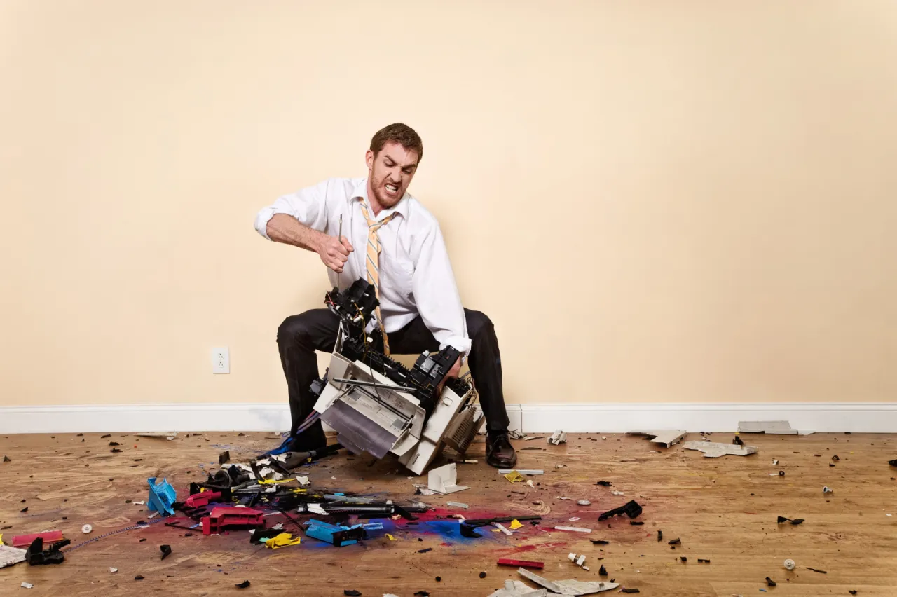 osoba naprawiająca drukarkę w domu