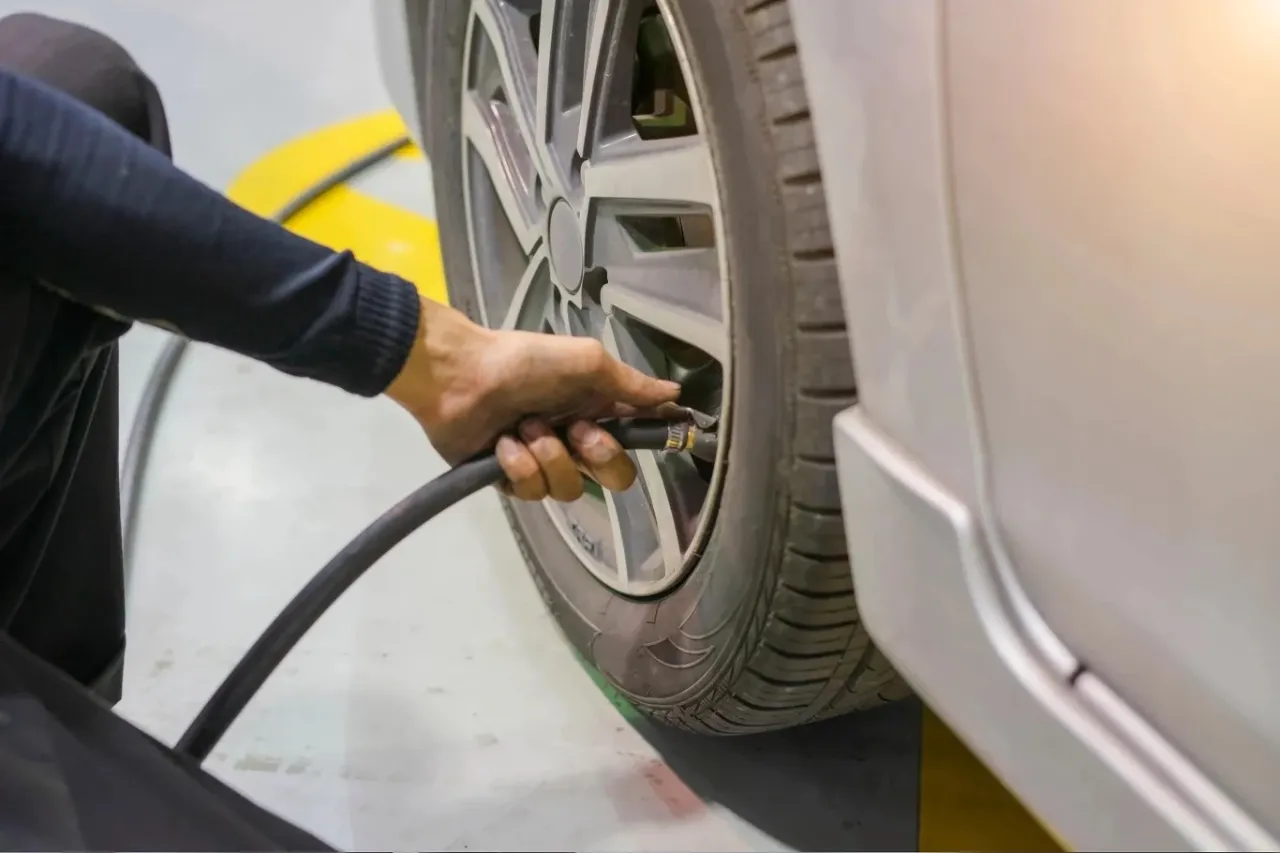 osoba pompująca oponę samochodu