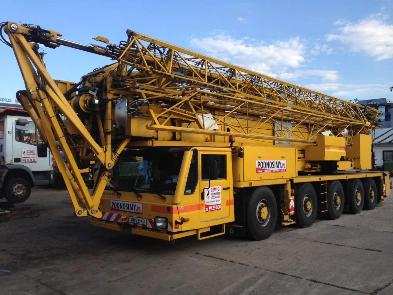 dźwig samojezdny w pracy, dźwig wieżowy na budowie, mini żuraw