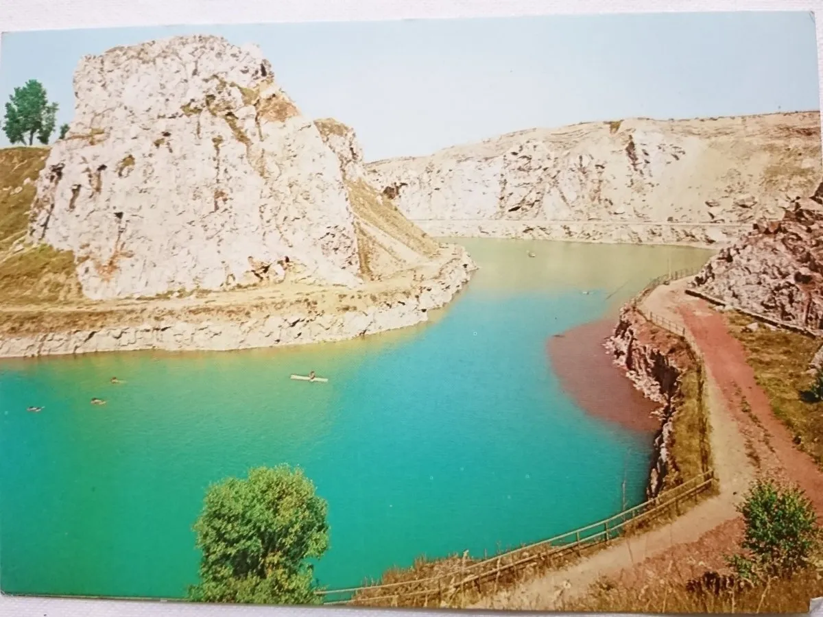 Turkusowa woda w kamieniołomie, dawniej rezerwat przyrody Kielce. Widać kajakarzy i skaliste zbocza.