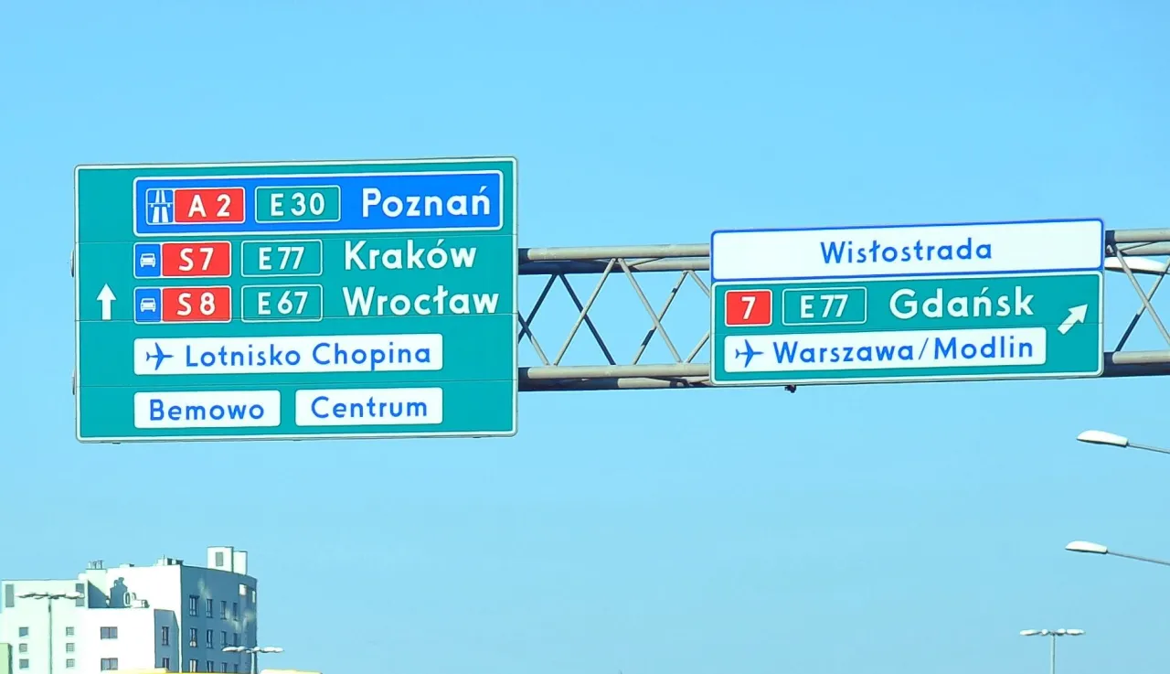 Znaki drogowe wskazują oznaczenie drogi wojew&oacute;dzkiej S7, S8, A2, E30, E77, E67 do Poznania, Krakowa, Wrocławia, Lotniska Chopina, Bemowa, Centrum, Wistostrada, Gdańska i Warszawy/Modlina.