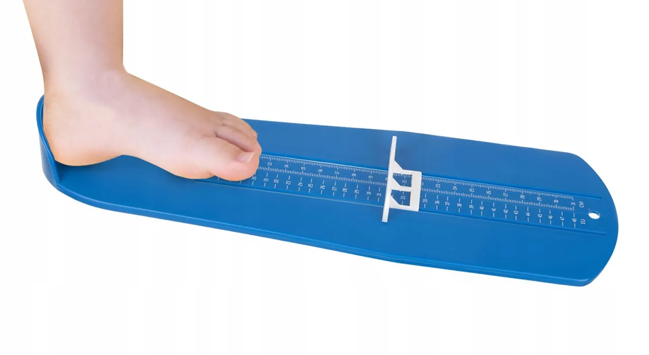 Kobieta mierzy stopę miarką krawiecką, pomiar tęgości stopy