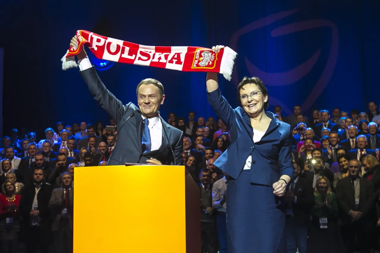 Donald Tusk i Ewa Kopacz, którzy rządzili w latach 2007-2015, pozdrawiają tłum z biało-czerwoną szarfą 