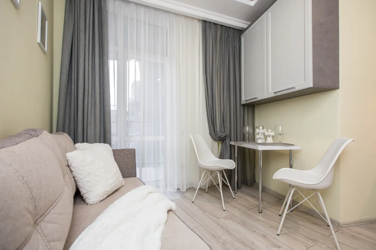 mała sypialnia z jasnymi zasłonami