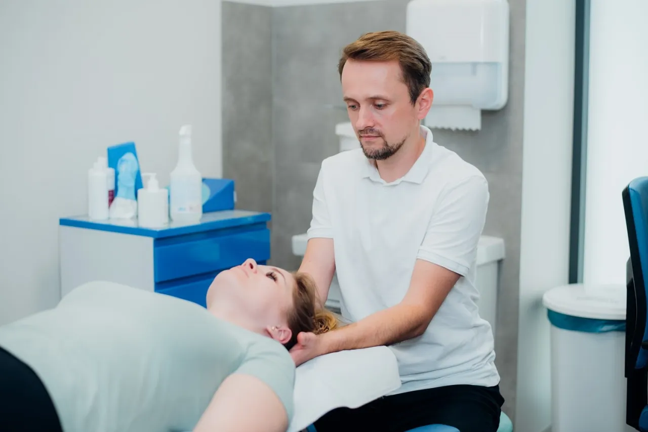 fizjoterapeuta pracuje z pacjentem na macie