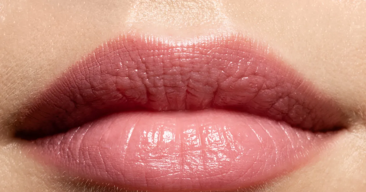 Kobieta delikatnie masująca usta, ciepły kompres na ustach