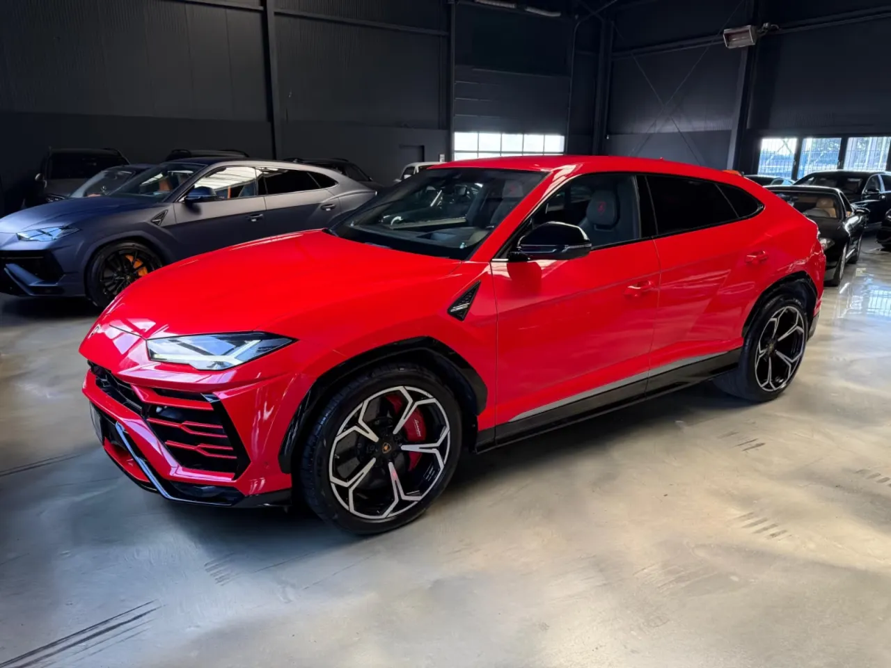 Czerwone Lamborghini Urus błyszczy w salonie. Zastanawiasz się, ile kosztuje lamborghini urus? Ten SUV to marzenie wielu.