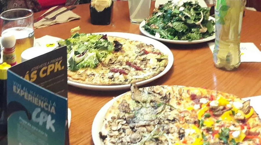 mesa con varias pizzas y platos de Pizzería California