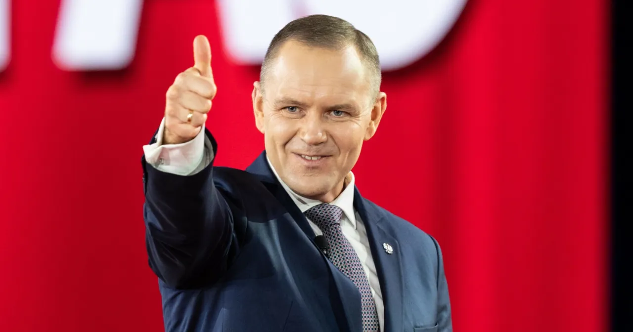 Karol Nawrocki z kciukiem w górę, uśmiechnięty, w garniturze. Jego popularność w sondażach prezydenckich z marca 2026 roku rośnie.