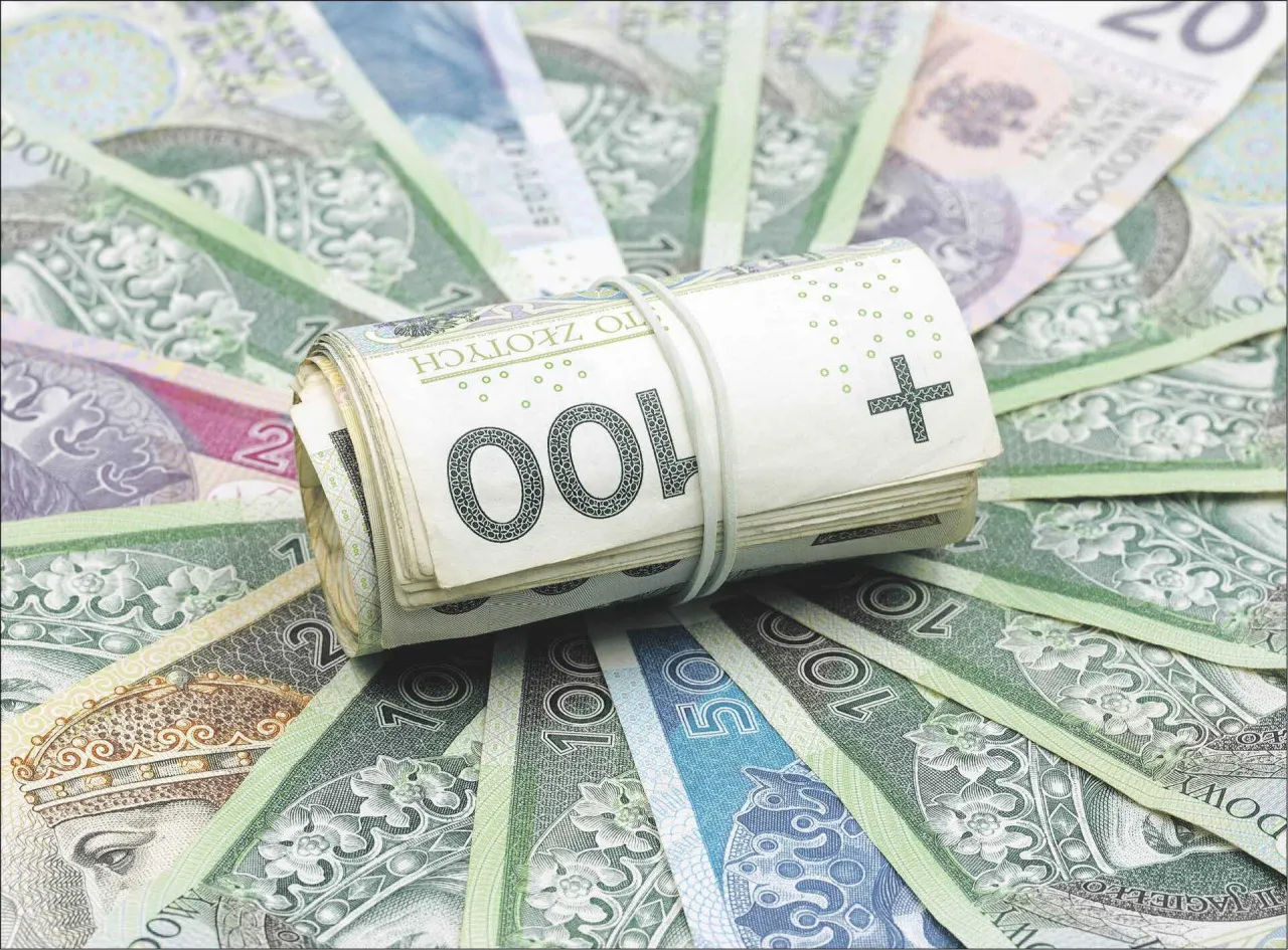 Zwijana sterta banknot&oacute;w 100 zł na tle innych polskich pieniędzy. Czy to symbol obaw, kt&oacute;re banki są zagrożone upadłością w Polsce?