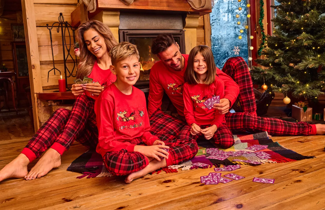 Rodzina w świątecznych piżamach przy kominku
