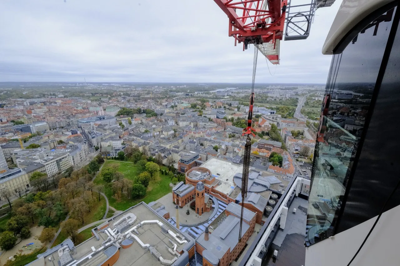 Operator dźwigu w kabinie widok z g&oacute;ry na plac budowy