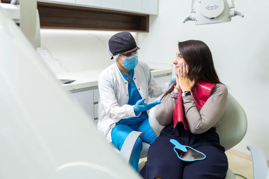 pacjent opisuje b&oacute;l zęba dentysta