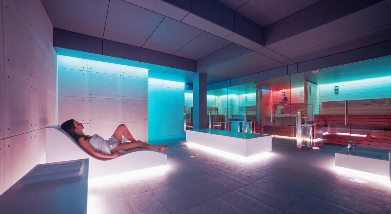 Osoba pakująca torbę na wyjazd do spa, z ręcznikiem i kosmetykami