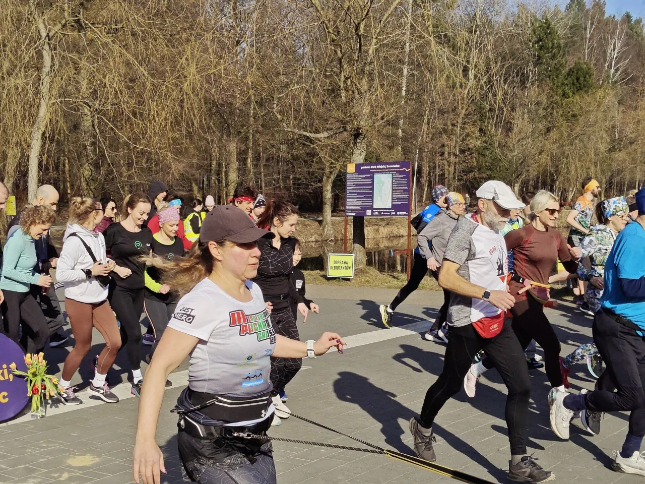 Kobieta biegnąca w parku z uśmiechem